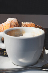 A cup of delicious morning espresso coffee with freshly baked croissant in Trieste, Italy