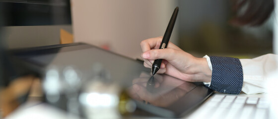 Female graphic designer working on graphic tablet in comfortable room