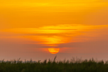 Fototapeta premium Sunset colors over a remote rural field, in autumn, along a wild river bank