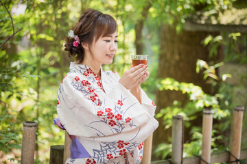 Obraz premium 飲み物を飲む浴衣姿の女性 