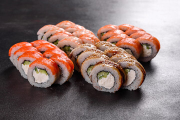 Fresh delicious beautiful sushi rolls on a dark background