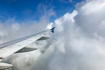 view from airplane window with puffy clouds 