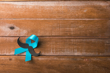November Blue, Light blue ribbon with a man mustache on wooden background, Men health awareness,...