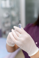 Syringe in hand`s in white gloves. Ready to make injection. Cosmetology concept. Closeup. Selective focus.