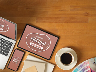 Mock up digital devices with laptop, tablet and smartphone on worktable