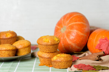 autumn pumpkin cupcakes with fresh pumpkin for thanksgiving day. autumn composition of pumpkin and maple leaves with pastries muffins