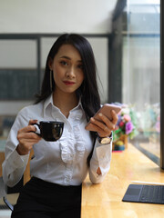 Female worker looking into camera while take a coffee break
