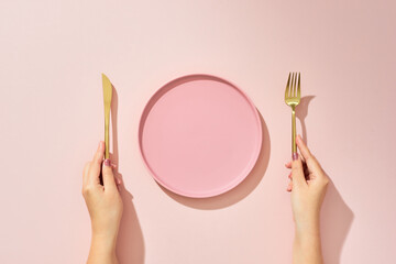 Woman with fork, knife and empty plate on pink background, top view - obrazy, fototapety, plakaty