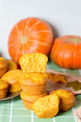 autumn pumpkin cupcakes with fresh pumpkin for thanksgiving day. autumn composition of pumpkin and maple leaves with baked muffins. the cupcake is broken into pieces