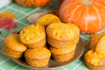 autumn pumpkin cupcakes with fresh pumpkin for thanksgiving day. autumn composition of pumpkin and maple leaves with pastries muffins