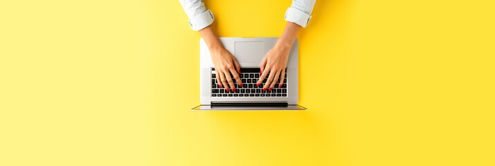 Fototapeta na wymiar Female hands working on laptop. Office desktop. Top view. Banner