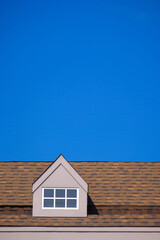 orange roof of the house with white window frame in dark blue clear sky