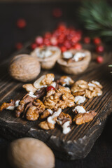 Walnuts with lingonberry on cutting board on table with pine