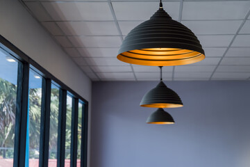 vintage style hanged ceiling lamp warm orange tone light color bulb light with dark blue tone dirty concrete background wall.