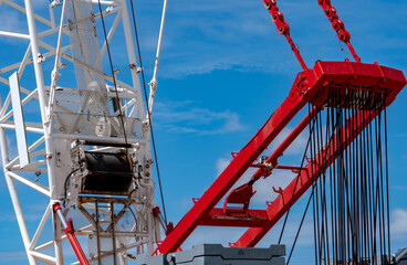 Closeup crawler crane with wire rope sling on crane reel against blue sky. Lifter equipment in...