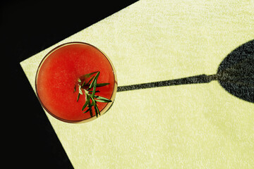 Cocktail in glass under hard light, shadow