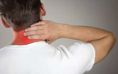 Pain in the neck of a man. Highlighted in red. On a gray background. Close up