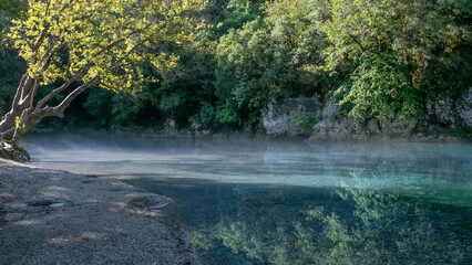 Obraz premium Mist over the Voidomatis river next to the papingo bridge in north Greece