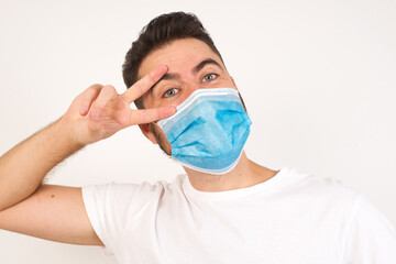 Leisure lifestyle people person celebrate flirt coquettish concept. Handsome young cheerful blond man showing making v-sign near eyes wearing casual clothes standing outdoors.