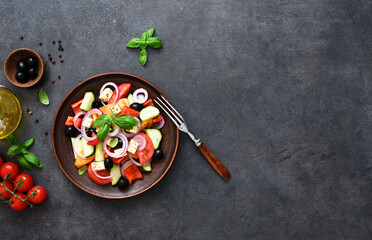 Greek salad with feta and olives on a black concrete background. View from above.