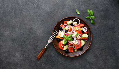 Greek salad with feta and olives on a black concrete background. View from above.