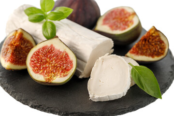 Fresh goat cheese and sweet figs on black stone board isolated