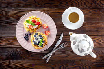 Breakfast with Belgian waffles on dark wooden background top view