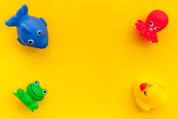The concept of children’s bath toys. Yellow background top view copyspace