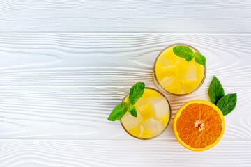 Summer drink from orange with ice on white wooden background top view flat lay copy space