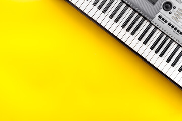 Musician work set with synthesizer, note and headphones Yellow table background top view space for...
