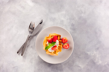 Homemade belgian waffles on gray marble background top view