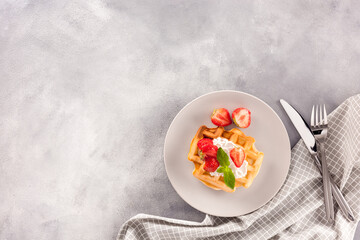 Homemade belgian waffles on gray marble background top view