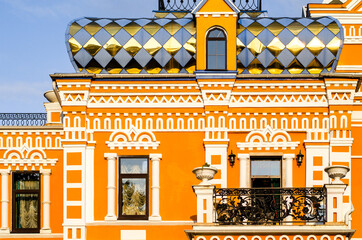 Fragment of a yellow facade with a balcony and stucco molding