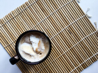 a cup of coffee on a wooden stand