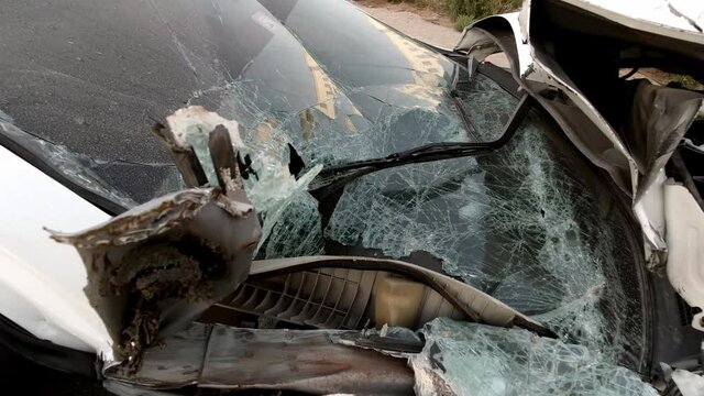 Totally wracked car after accident. Broken car on the side of the road. Body of the car is damaged as a result of an accident. High speed head on a car traffic accident. Concept of car insurance