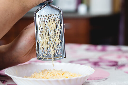 Woman grating cheese on the table