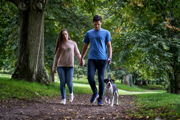 Obraz premium Young couple walking dog