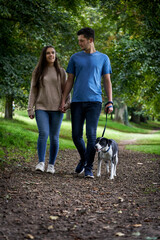 Young couple walking dog