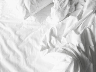 Soft and calm atmosphere image of all white bed room. Pillows and blanket on empty bed, close up