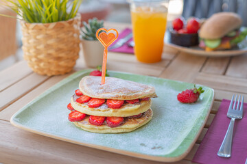 Close-up delicious pancakes with fresh strawberries and chocolate sauce. Breakfast concept.