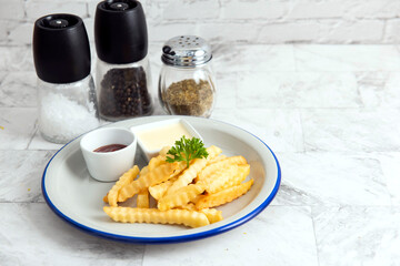 Tasty french fries on plate, on marble table background