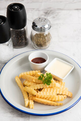 Tasty french fries on plate, on marble table background