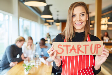 Junge Frau als Restaurant Gründerin mit Schild