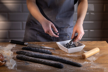 Chef preparing and arranging ready for cooking black dumplings with sepia addition. Cooking dumplings – step by step guide.