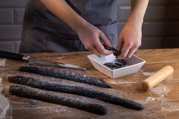 Chef preparing and arranging ready for cooking black dumplings with sepia addition. Cooking dumplings – step by step guide.