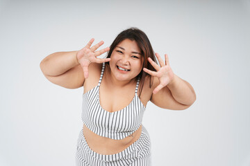 Cheerful healthy asian chubby woman showing two hands on white background.