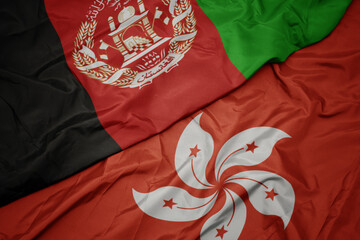 waving colorful flag of hong kong and national flag of afghanistan.