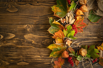 Naklejka na ściany i meble wreath of autumn leaves and natural materials on rustic wooden boards. Top view