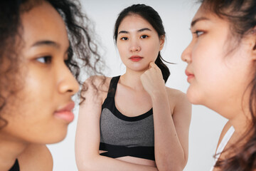 Portrait of asian business woman standing among chubby and african women.