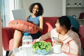 African and asian women working and having lunch together.